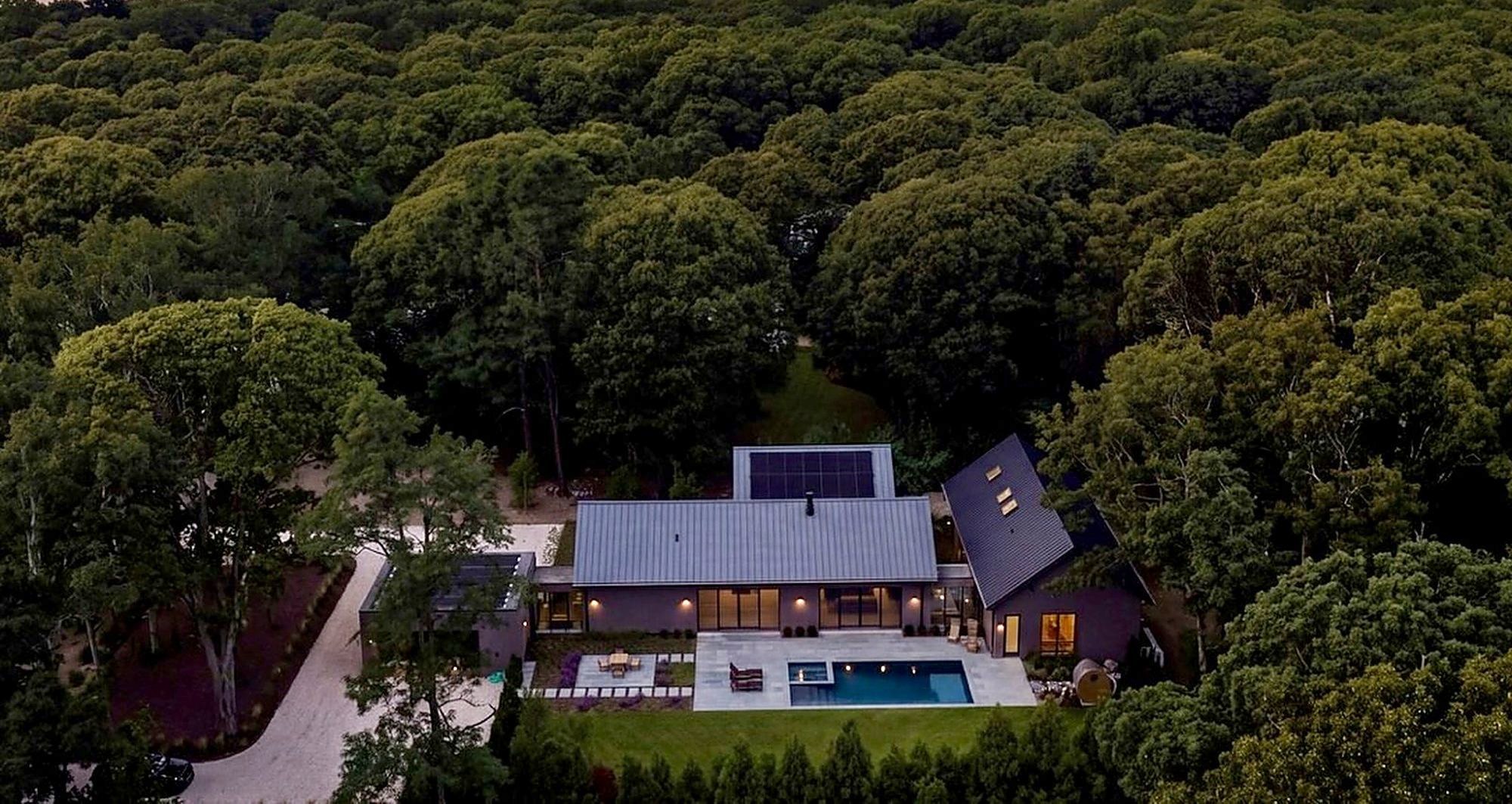 The house held within the tree canopy, seen from the air
