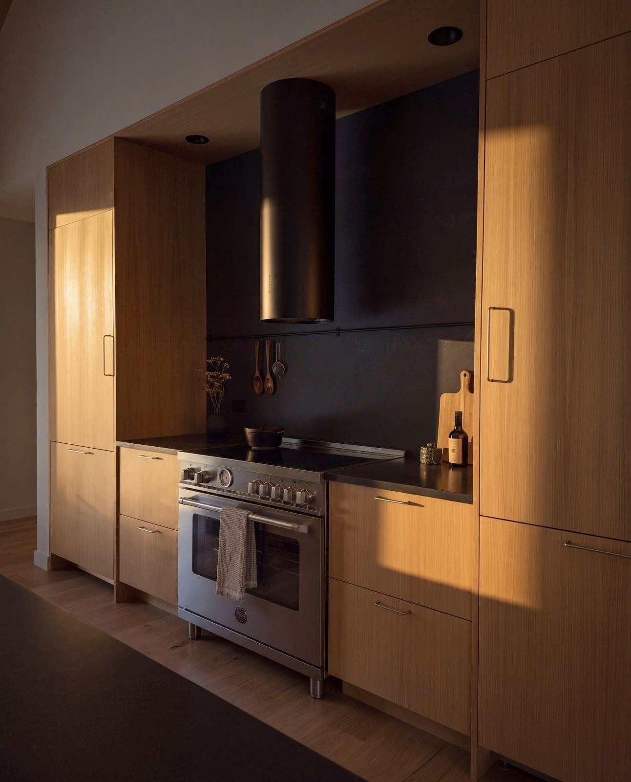 The range under a plaster hood, oak cabinets either side